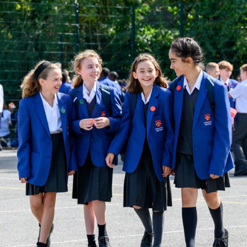 Four young students chatting in the school playground