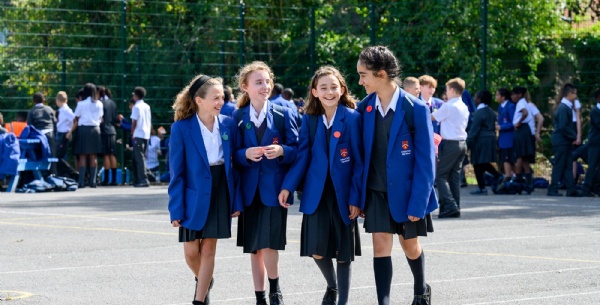 Four young students chatting in the school playground